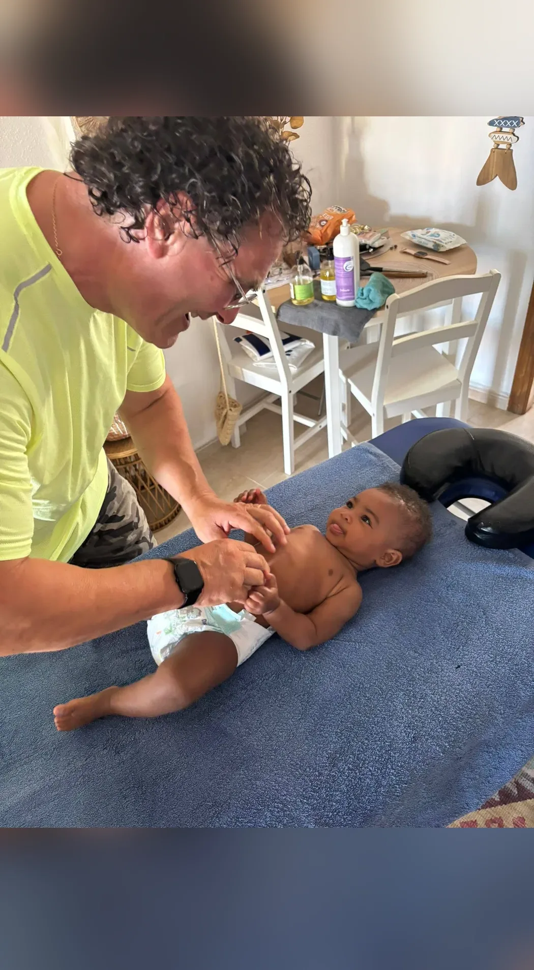 Pasqual masse un bébé sous le regard de sa maman
